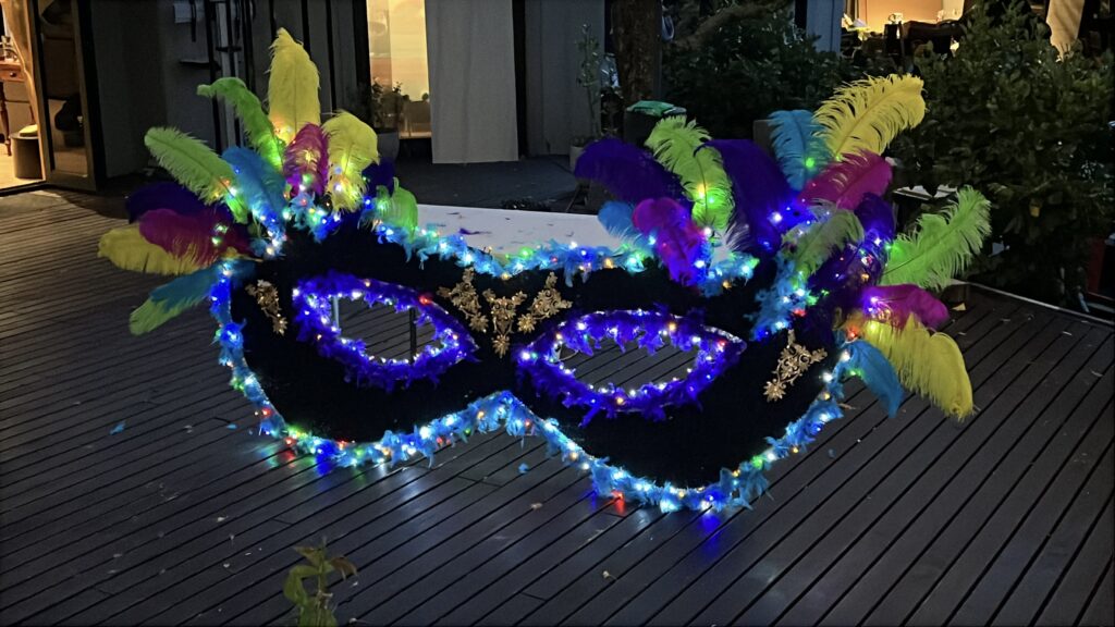 Jumbo carnival mask prop with colourful feathers and LED fairy lights for Rio and carnival themed events in Auckland