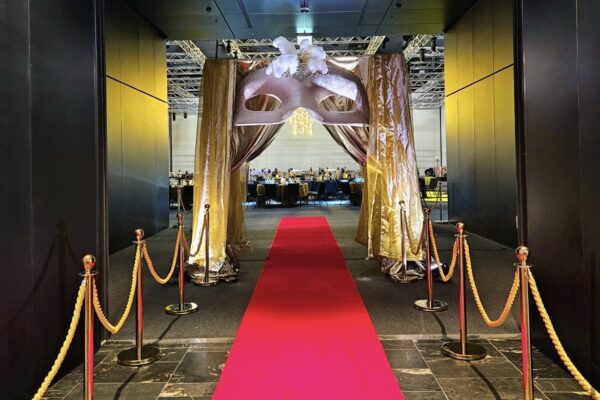 Luxury masquerade theme hire in Auckland with oversized masks, feathers, backdrops, marquee numbers, entrance styling and elegant event decor for balls, galas and themed events.