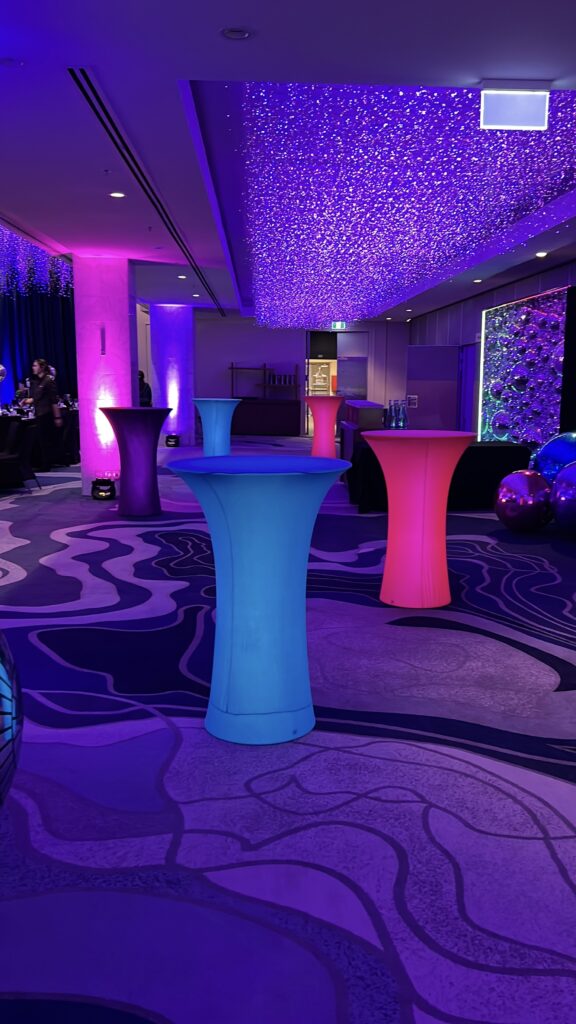 LED cocktail tables glowing pink and blue at an Auckland event venue