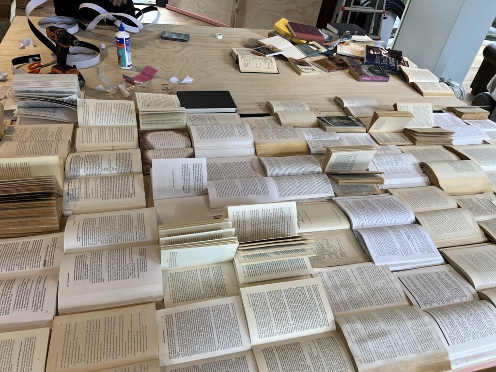 Handmade book wall pages being created for custom event styling by PartyCrate Auckland